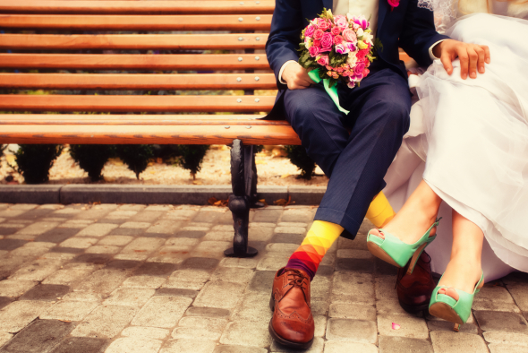 Bride and groom in bright clothes on the bench